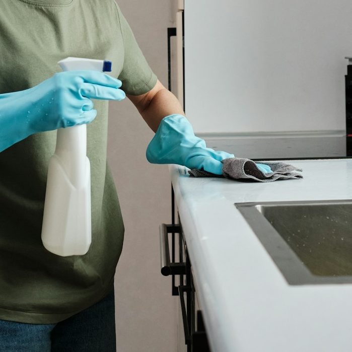 A person thoroughly cleans a kitchen countertop, a deep cleaning service rendered by Kals Kleans in Milton Keynes