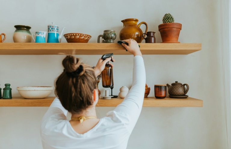 A person decluttering a shelf, a home organisation service by Kals Kleans in Milton Keynes